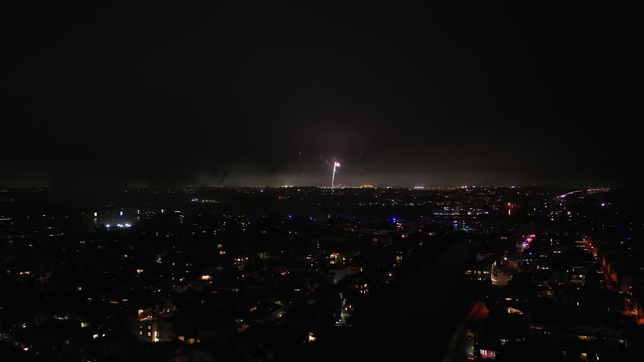 July 4 fireworks light up dark Los Angeles city night, aerial view