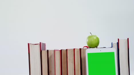 apple, digital tablet and books on white background