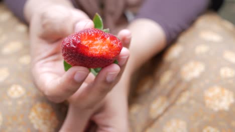 women holding a strawberry fruit