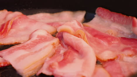 close up of frying bacon in a pan