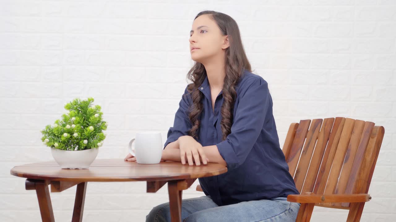 카페에서 누군가를 기다리고 있는 인도 소녀