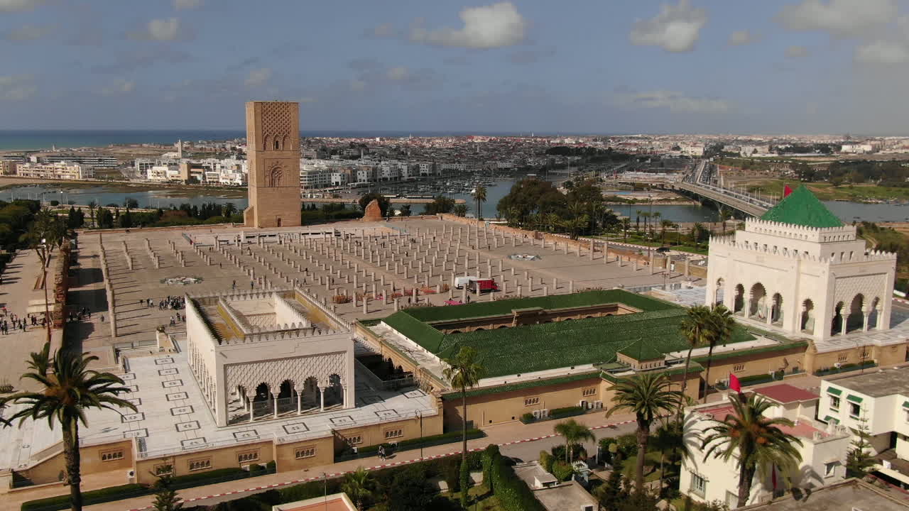 Fantastisk HD luftpanorama af det historiske Hassan Tårn-kompleks og det hvide marmormausoleum af V i Rabat, Marokko. Dette vidvinkelbillede fanger de antikke søjler og den ikoniske grøntaggede tårntop.