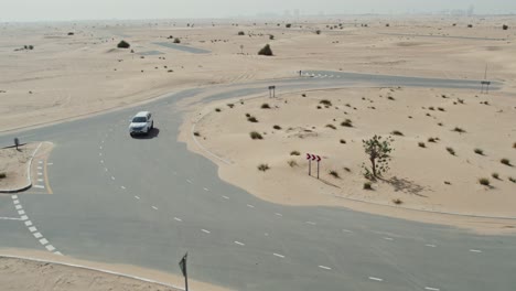 car driving through a roundabout in the desert