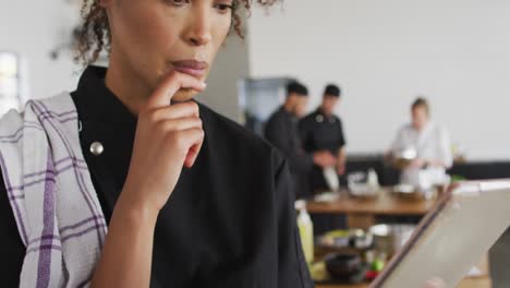 Mixed-race-female-chef-using-digital-tablet