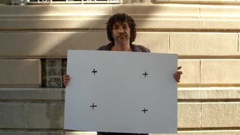 mature homeless man with blank poster