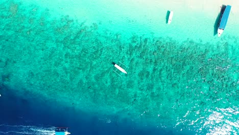 Harbour-Island,-Bahamas---Wonderful-Scenery-Of-Boats-Floating-By-The-Green-Sea-During-Sunny-Day---Aerial-Shot