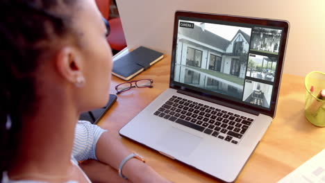 mujer afroamericana viendo cámaras de cctv en su computadora portátil, cámara lenta