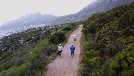 two people running on a mountain trail