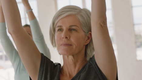 yoga class portrait beautiful old woman practicing prayer pose enjoying healthy lifestyle group meditation in fitness studio