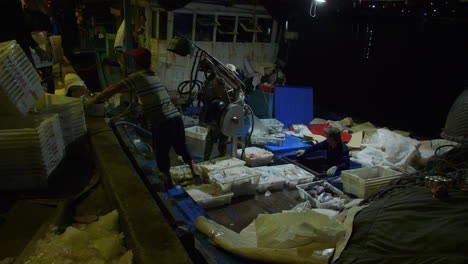 Fisherman-unloading-fresh-caught-fish-from-boat-for-trading-in-market,-Tho-Quang-Port,-Vietnam