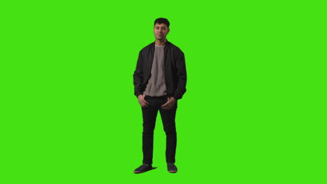 Full-Length-Shot-Of-Smiling-Casually-Dressed-Young-Man-Standing-Against-Green-Screen-With-Hands-In-Pockets-1