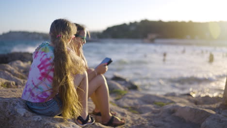 mother and daughter relaxing at the beach sunset