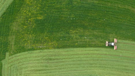 tractor works in farm field - aerial top down