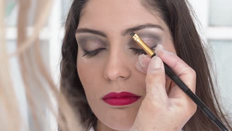 visagista de cultivos aplicando maquillaje en el modelo