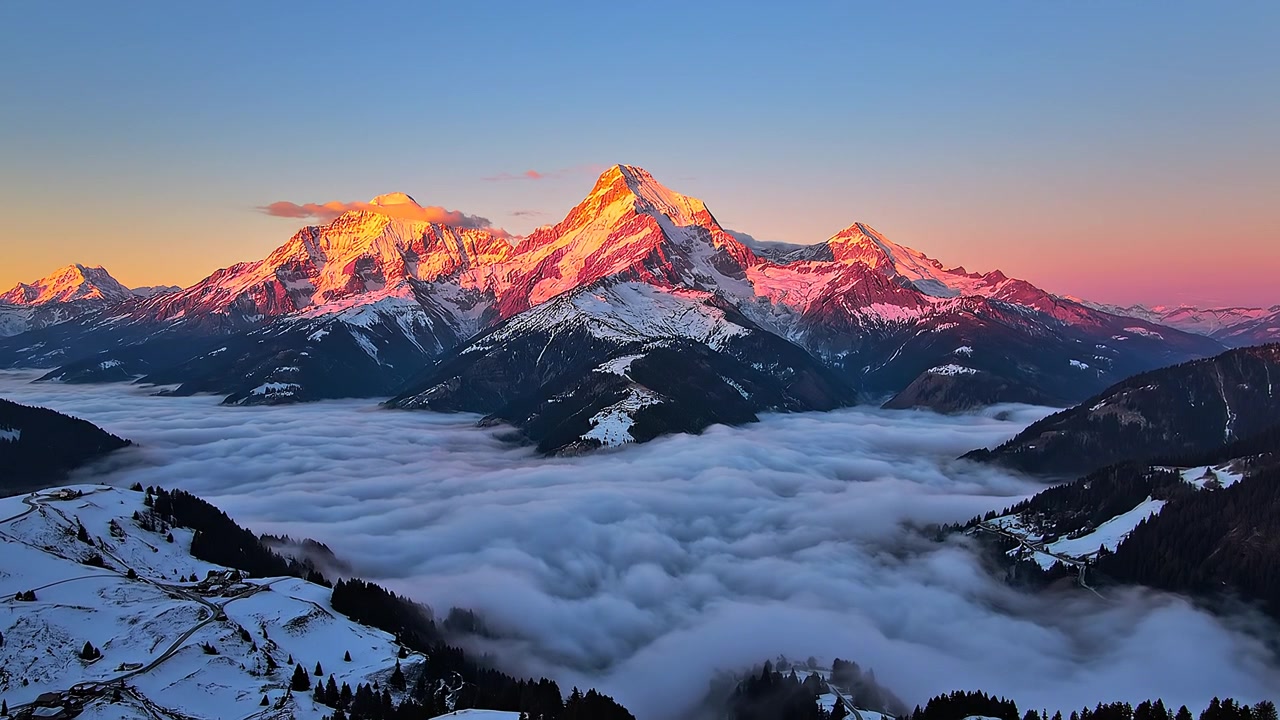 Sommets majestueux de montagnes enneigées au-dessus d'une mer de nuages dense