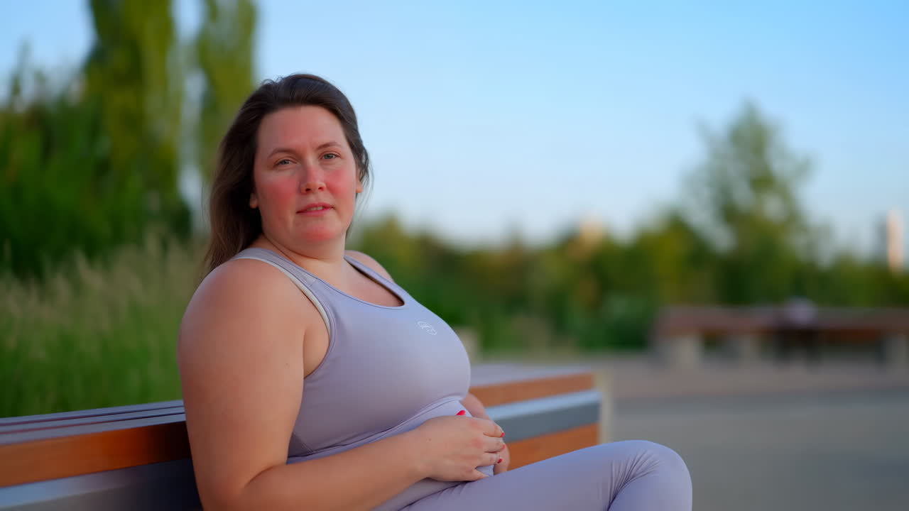 Donna in abbigliamento sportivo seduta su una panchina all'aperto