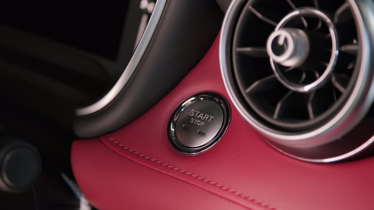 운전자의 손은 자동차 엔진을 시작하기 위해 버튼을 누르며, 엔진의 열없는 점화 시작, 교통과 기술의 개념.