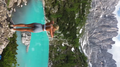 woman hiking and posing by a stunning turquoise alpine lake