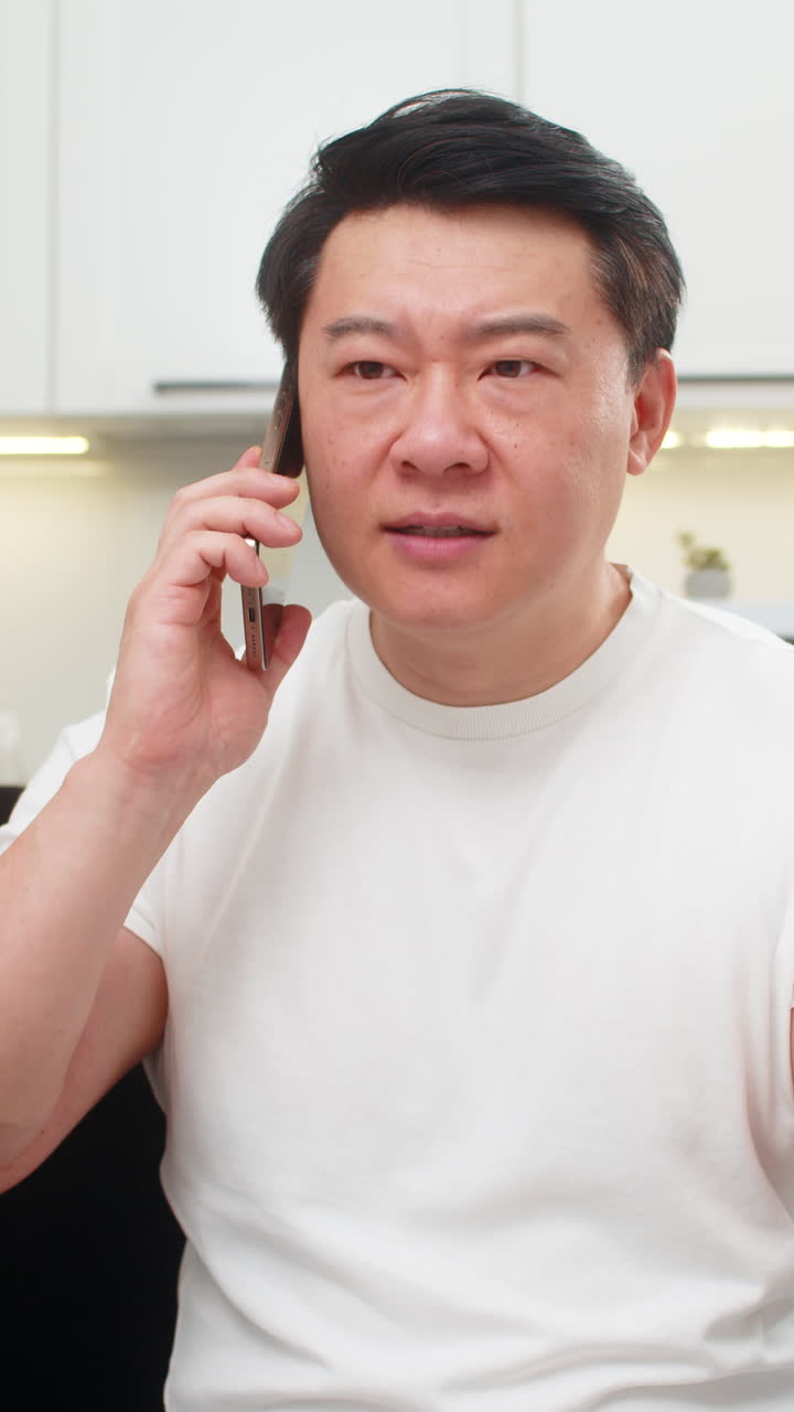 Asian man argues on smartphone frowns shows no no finger gesture speaks firmly and rejects request