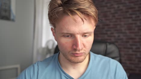 A-front-facing-closeup-of-a-young-man-studying-the-computer-task-in-front-of-him-and-making-decisions-as-to-what-to-code-next