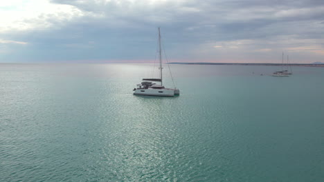 Aerial-View-Of-A-Catamaran-Boat-Floating-In-The-Open-Sea-In-Mallorca,-Spain