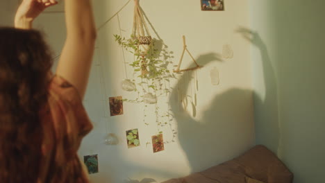 young woman dancing in cozy room, casting shadows on sunlit wall