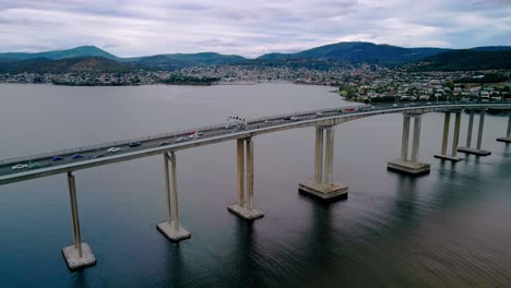 aerial parallax shot of bridge with cityscape at background