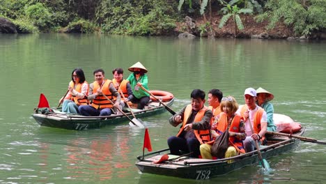 group of people rowing boats in teamwork exercise