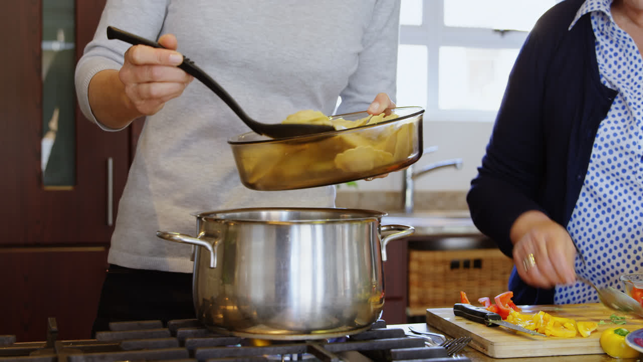 madre e hija preparando comida en la cocina en casa 4k