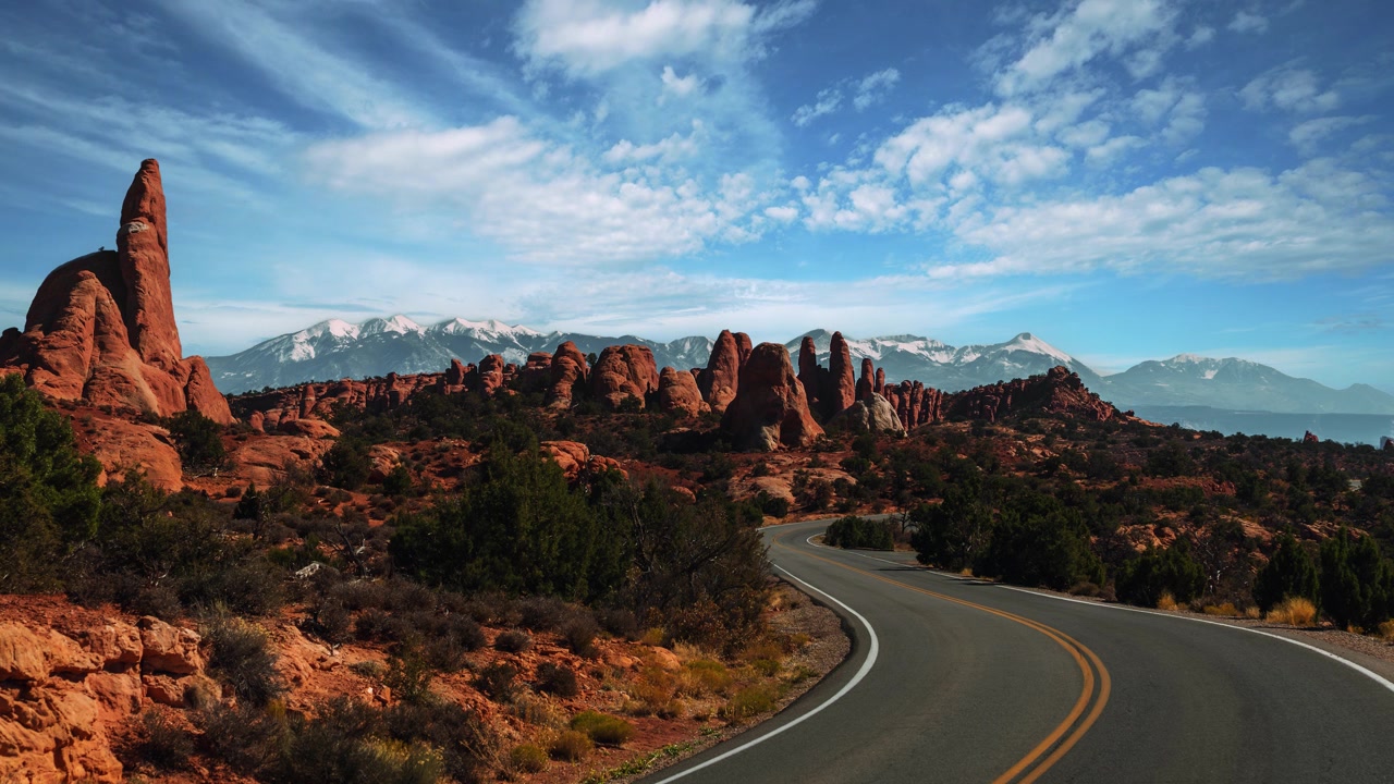 Time-lapse di nuvole, guglie di roccia rossa e strada panoramica, deserto dello Utah, Parco Nazionale degli Arches