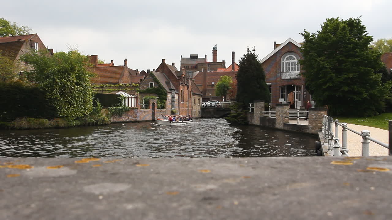 una barcaza llena de turistas navega por un canal de agua en bélgica