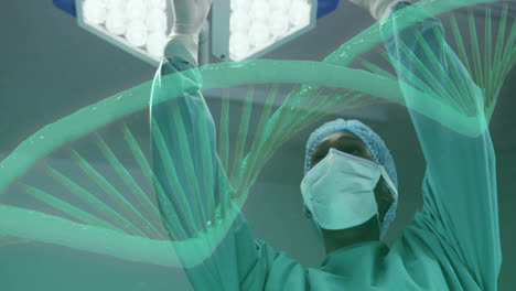 animation of dna strand rotating over african american female surgeon working in theatre