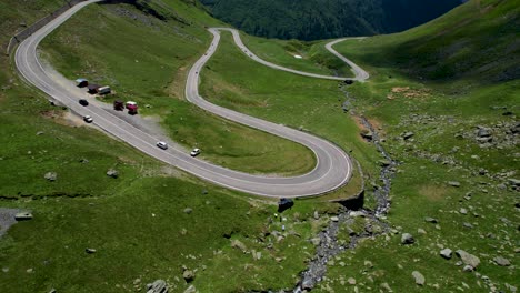 beautiful aerial view of transfagarasan mountain road crossing the carpathian mountains in romania, aerial view of a beautiful mountain range with high peaks, thick fluffy clouds