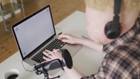 feliz albino hombre afroamericano con rastas haciendo podcast