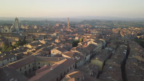 Aerial-sunset-cityscape-of-Siena-drone-fly-above-old-medieval-town-in-Tuscany-Italy