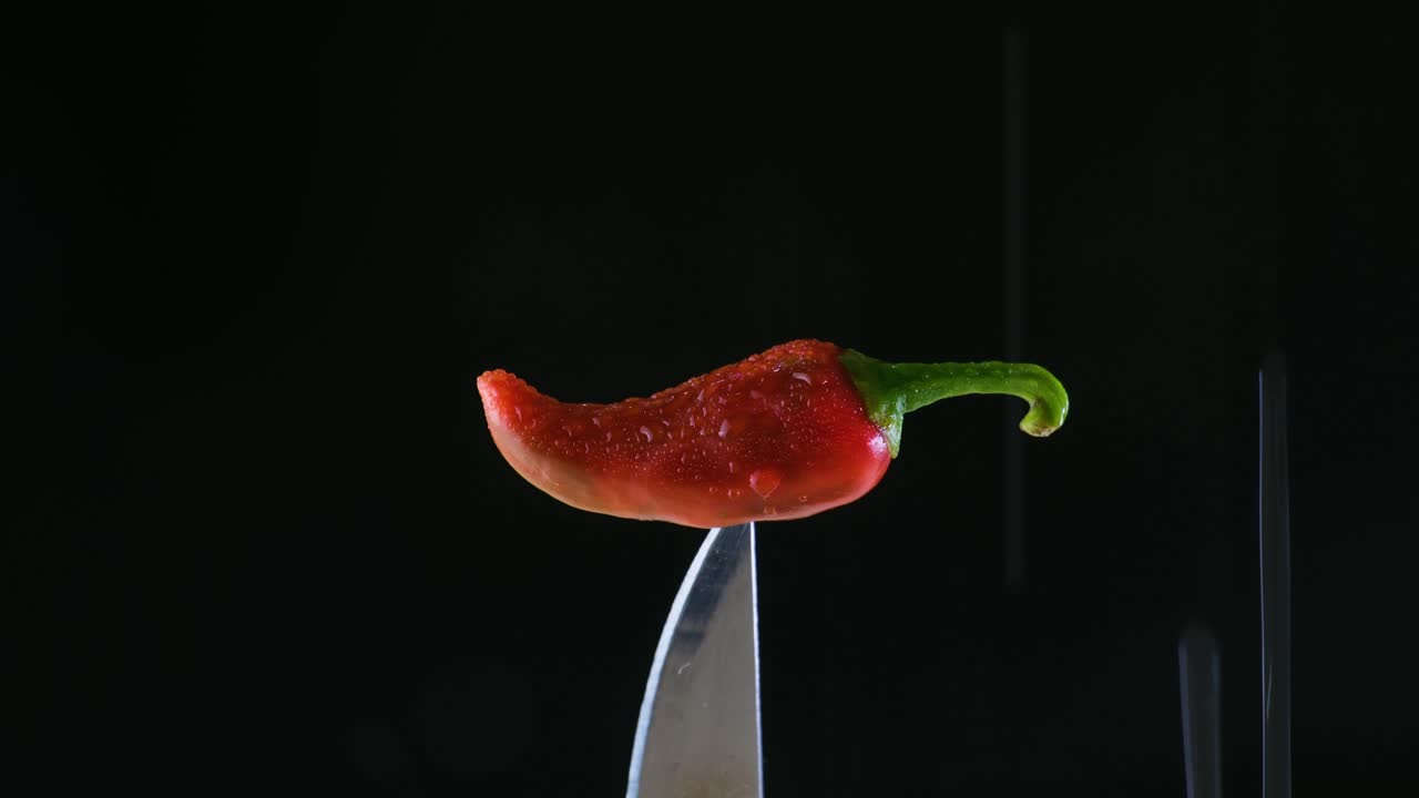 검은색 배경 의 칼 끝 에 은 칠리 고추 에 물 이 흘러 내리는 것 - 장면 뒤 에 있는 음식 광고