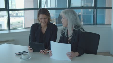 positive female managers discussing and analyzing reports