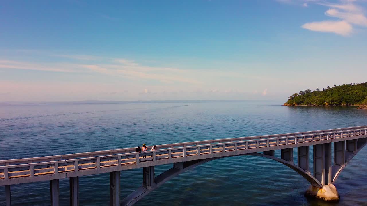 Samana bay bridge with people watching at town, aerial orbit view