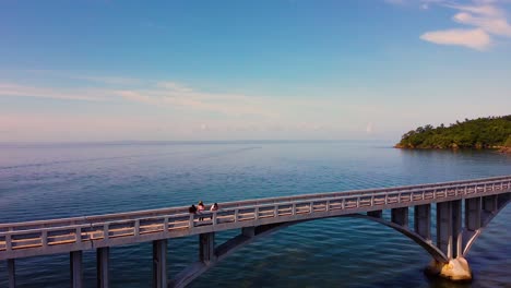 samana bay bridge with people watching at town, aerial orbit view
