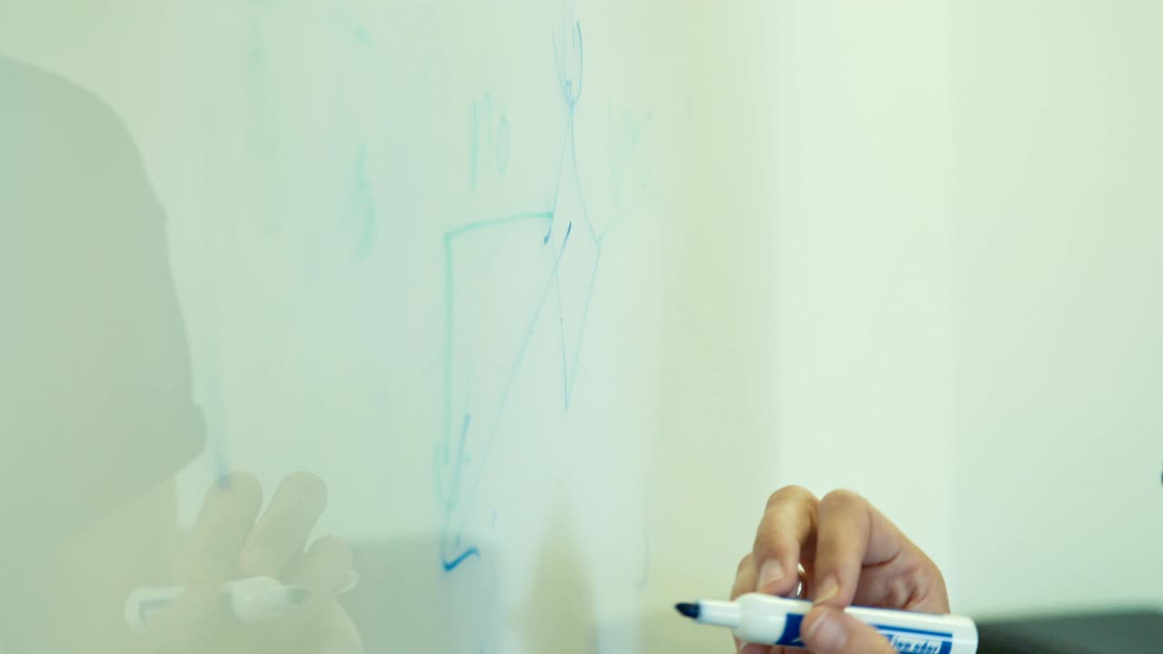 primer plano de manos dibujando en una pizarra