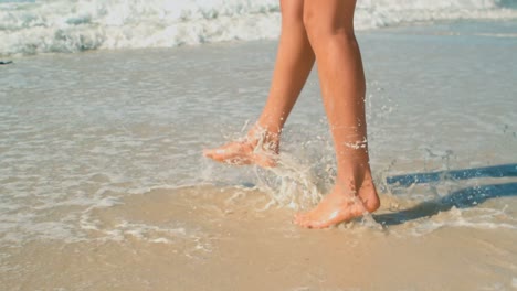 mujer jugando en las olas en la playa al sol 4k