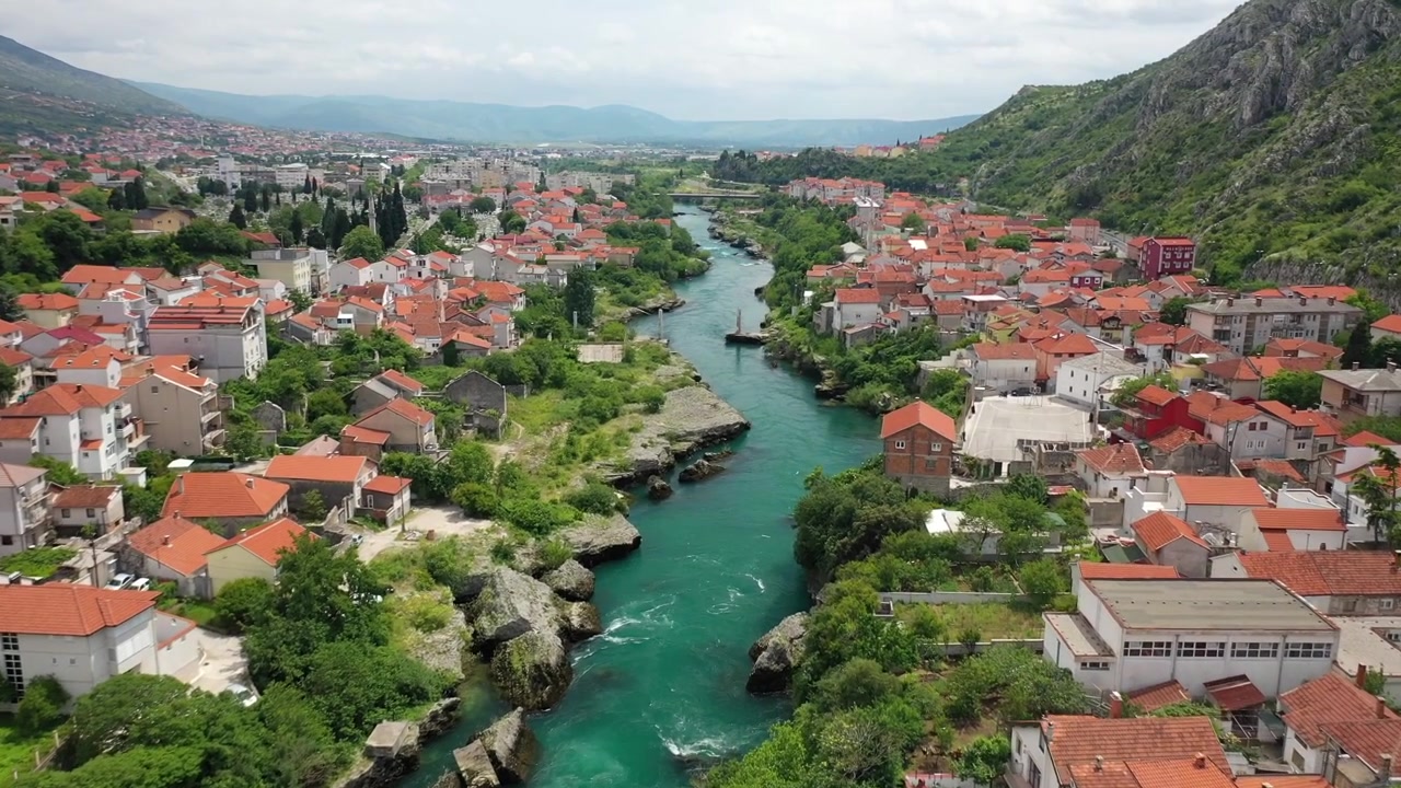 Vista aérea deslumbrante de drone da histórica Stari Most (Ponte Velha) sobre o rio Neretva cor de esmeralda em Mostar, Bósnia e Herzegovina. Apresenta arquitetura otomana tradicional e turistas