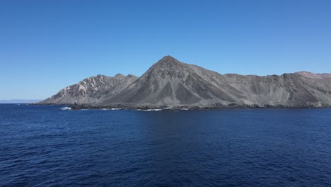 pan across dramatic mountain and hillside by rocky ocean coast