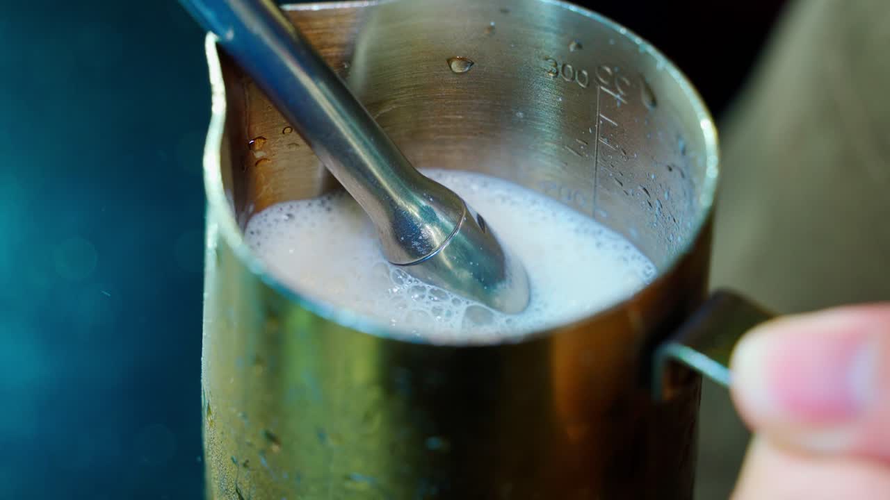 der barista dampft milch mit einer dampfmaschine