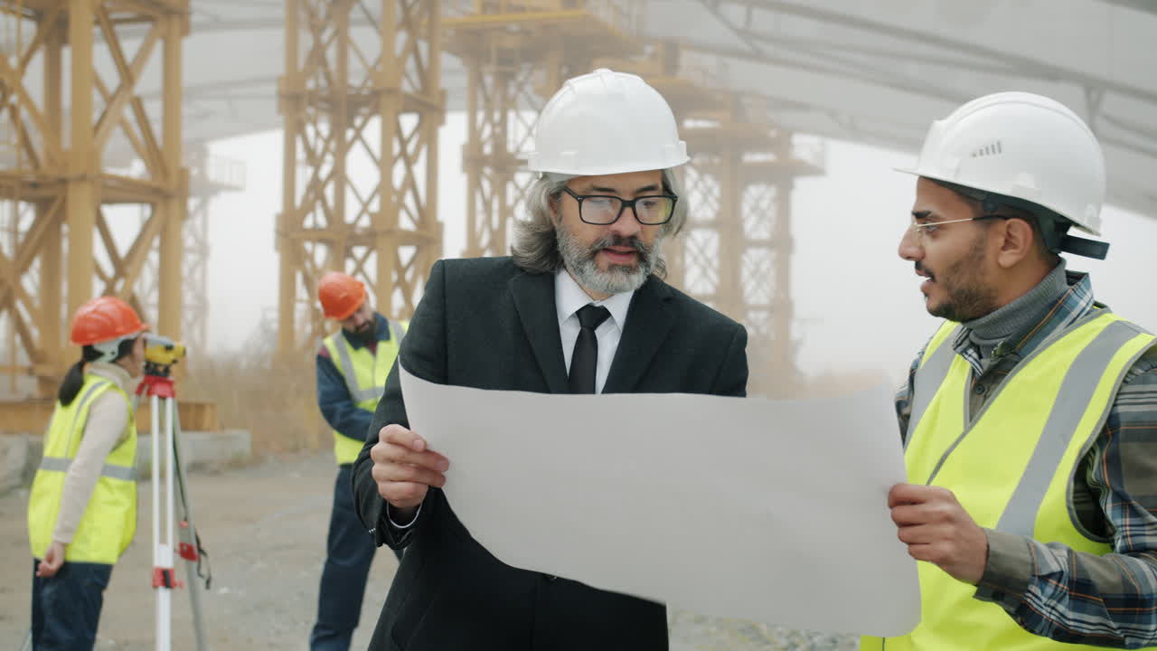 Construction Engineers Reviewing Blueprint on Site