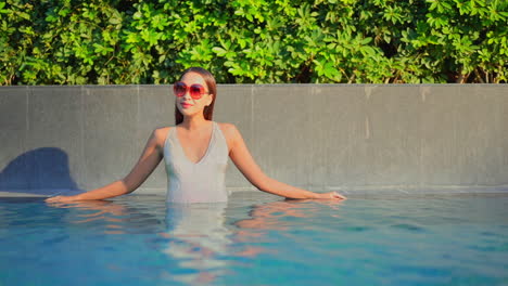 Sexy-Asian-Woman-in-Swimsuit-Standing-by-Pool-Border-and-Enjoying-on-Sunny-Day