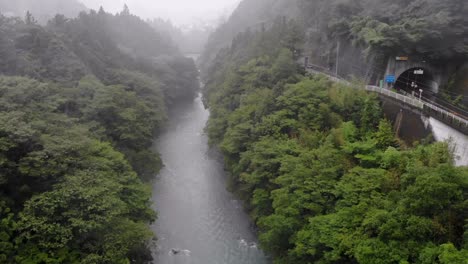 ascending drone shot over a river on a misty foggy rainy day