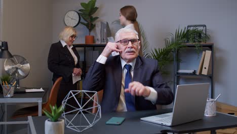 Portrait-of-business-man-in-office-looking-camera-doing-phone-gesture-like-says-hey-you-call-me-back