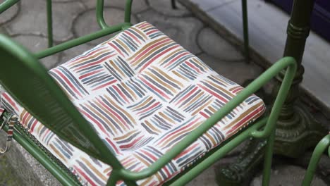 close-up of a green metal chair with a patterned cushion