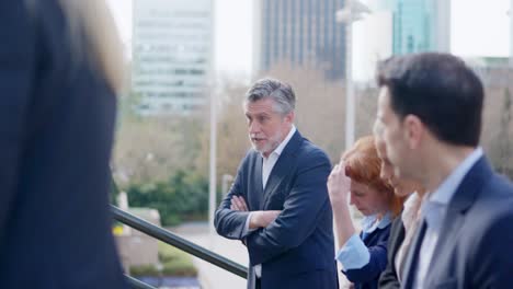 group of business professionals engaged in discussion outdoors